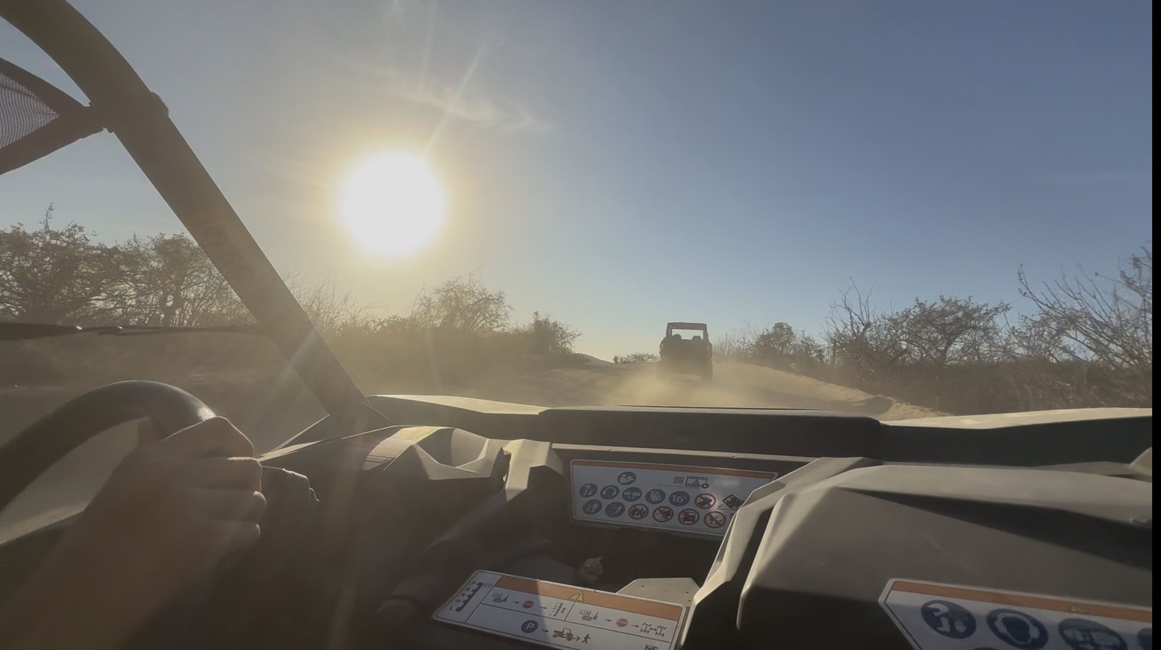 POV chasing another UTV through blinding sun and dust in Los Cabos